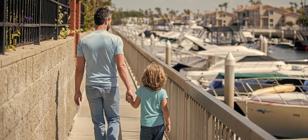 Alleinerziehender Vater, der ein kleines Kind außerhalb der Rückansicht der Zweisamkeit führt