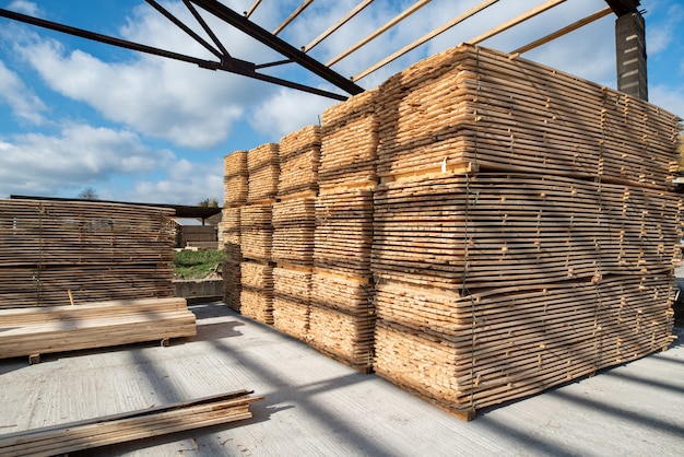 Almacén para aserrar tablas en un aserradero al aire libre. Molino de madera, aserradero: almacenamiento de tablas de madera cepilladas