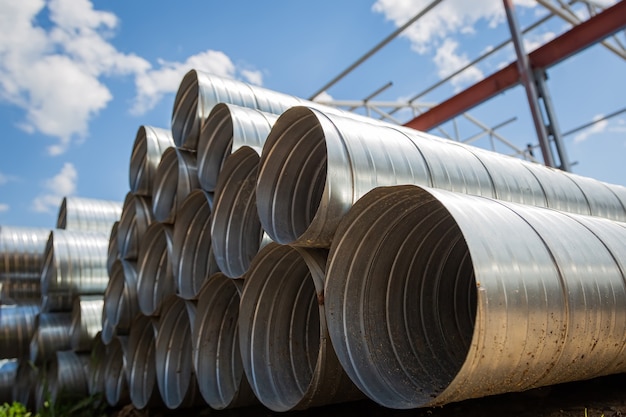 Almacén de tubería de ventilación. Tubos de acero, piezas para la construcción de conductos de aire para un sistema de aire acondicionado industrial en un almacén. Equipos de ventilación industrial de vías respiratorias y sistemas de tuberías.