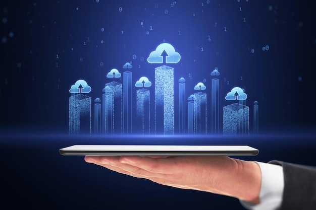 Almacenamiento de datos y concepto de servicio de computación en la nube con rascacielos de la ciudad azul brillantes visualización con iconos de nube por encima de la tableta digital en hombre de negocios mano en fondo oscuro