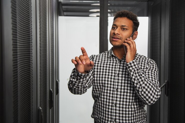Foto almacenamiento de informacion. técnico de ti pensativo hablando por teléfono y apuntando con el dedo