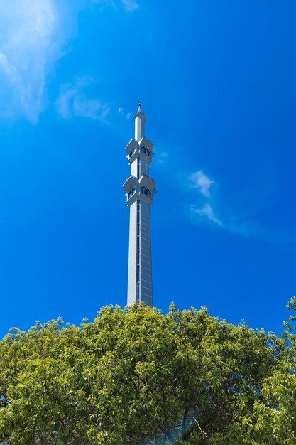 AlMarkaz-Moschee-Turm und Bäume an einem sonnigen Tag