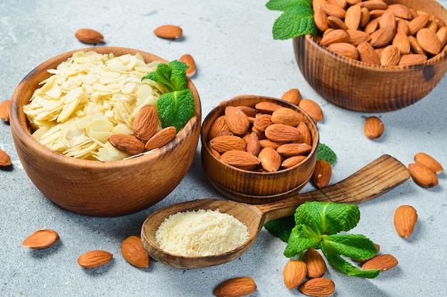 Almendras y chips de almendras en tazones Sobre un fondo texturizado gris claro Copiar espacio