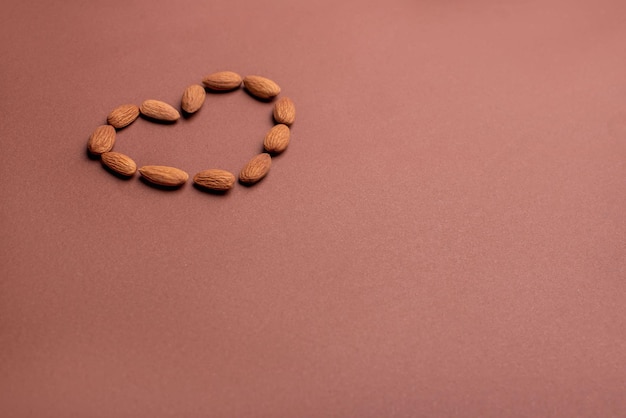 almendras dispuestas en forma de corazón sobre un fondo de papel marrón