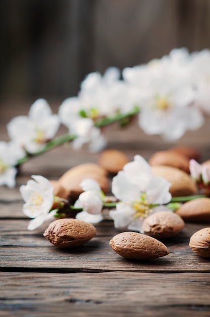 Almendras frescas y flores en la mesa de madera