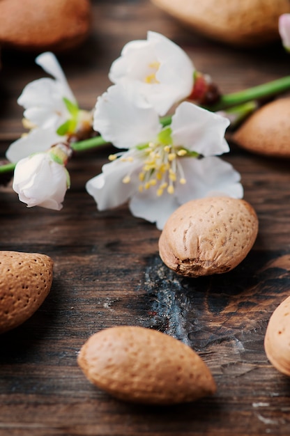 Almendras frescas y flores en la mesa de madera