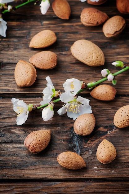 Almendras frescas y flores en la mesa de madera