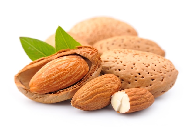 Almendras con hojas de cerca sobre el blanco