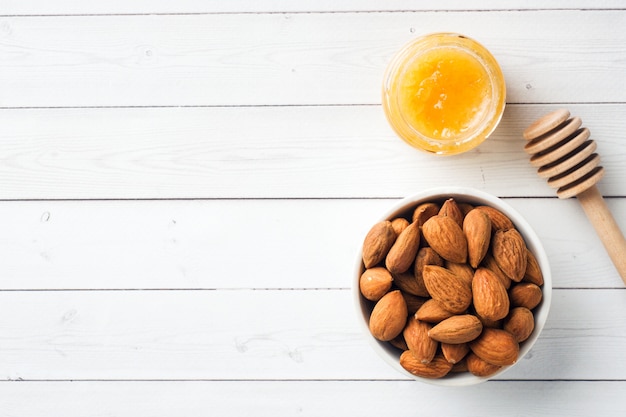 Almendras y una lata de miel en el fondo de la mesa