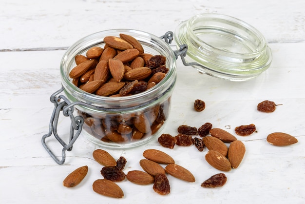 Almendras con pasas secas en un frasco de vidrio