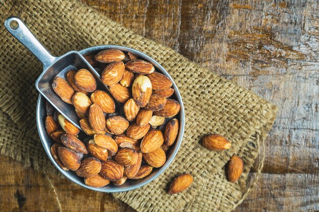 Almendras saludables en un recipiente en una mesa de madera