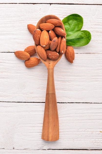 Almendras sobre un fondo blanco de madera Aperitivos saludables Vista superior Espacio libre para texto