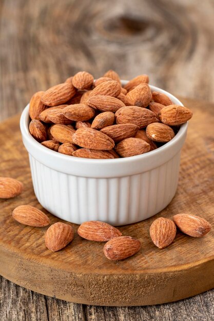 Foto almendras sobre fondo de madera almendras orgánicas y frescas en un plato de cerca