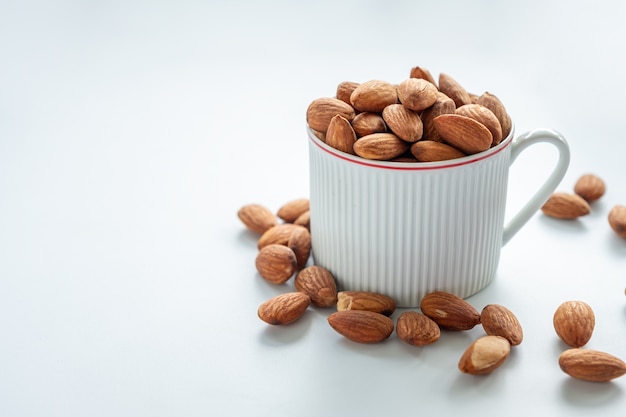 Almendras en taza blanca sobre fondo