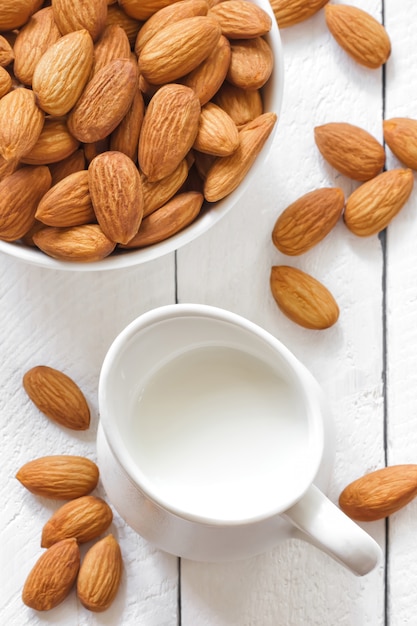 Almendras en un tazón con jarra de leche