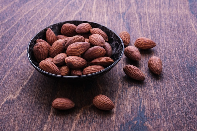 Almendras en un tazón en la mesa de madera