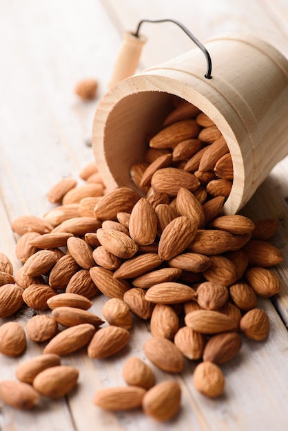 Almendras vierten del cubo de madera