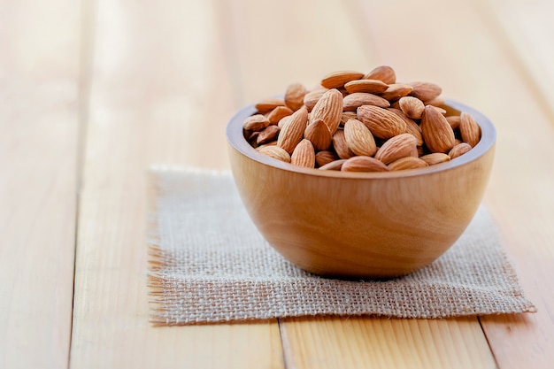 Las almendras se vierten de la taza de madera