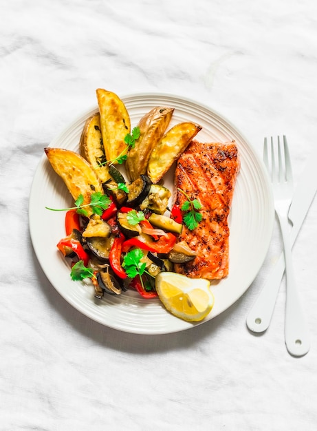 Almoço equilibrado saudável ratatouille assado de salmão grelhado e batatas em uma vista superior de fundo leve