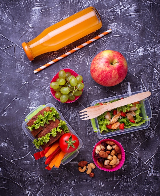 Almoço escolar. Salada, sanduíches, frutas e nozes