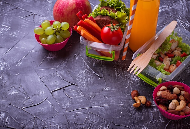 Almoço escolar. Salada, sanduíches, frutas e nozes