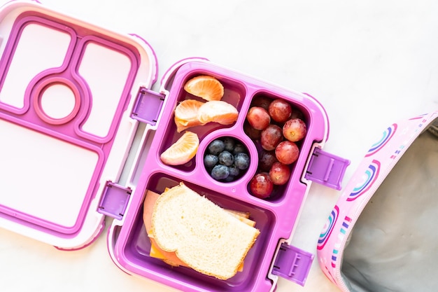 Almoço escolar saudável embalado em uma caixa de bento para uma menina.