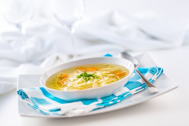 Almoço pondo mesa com frango ou sopa de carne com macarrão, cenoura e ervas.