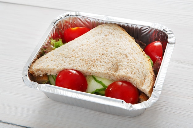 Almoço saudável e conceito de dieta. Tire a comida. Sanduíches com pão integral, pepino e tomate em lenha branca