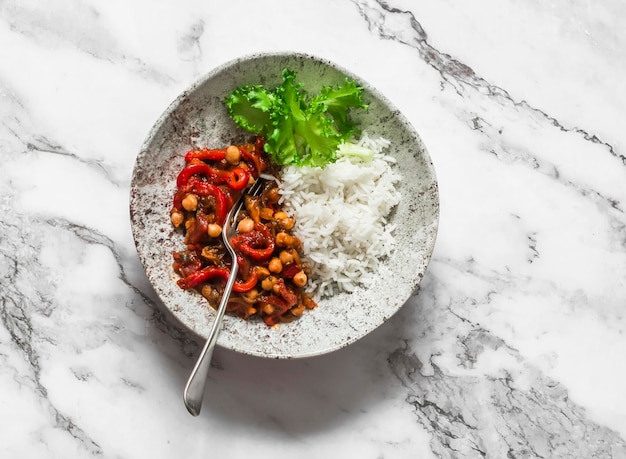 Almoço vegetariano arroz e berinjela pimentas tomates grão de bico guisado em uma vista superior de fundo leve