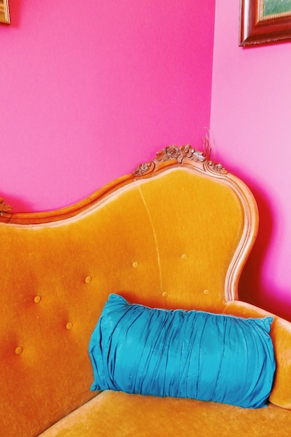 Almofada azul no sofá junto à parede rosa em casa