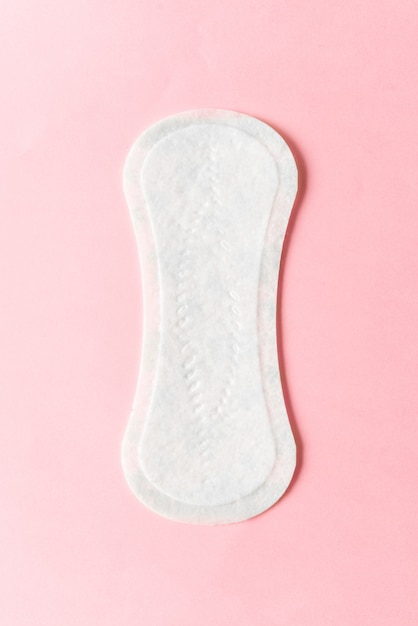 Almofada de higiene feminina em um fundo rosa. Conceito de higiene feminina durante a menstruação.