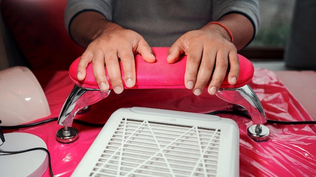 Almofada de mãos masculinas latinas após manicure profissional em um salão fechado