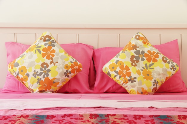 Almofada de polca colorida na cama-de-rosa