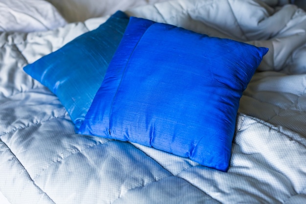 Almofadas azuis em uma cama no quarto