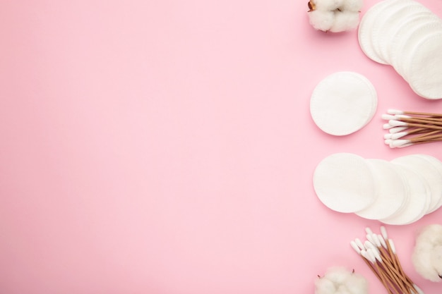 Almofadas cosméticas descartáveis higiênicas e flor de algodão em rosa. Vista do topo