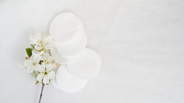 Almofadas cosméticas e flor do produto higiênico no fundo branco