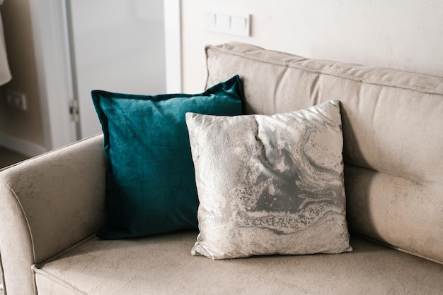 Almofadas decorativas de cor cinza e turquesa no sofá em uma aconchegante sala de estar