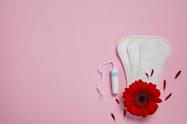 Almofadas menstruais tampões e flor vermelha