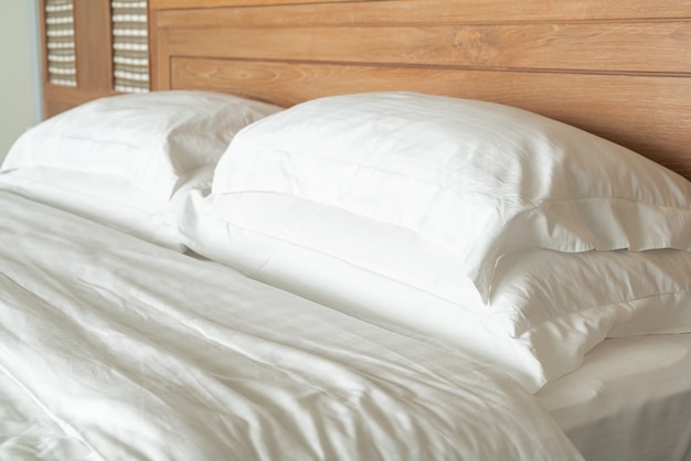 Foto almohada blanca en la decoración de la cama interior de la habitación del hotel