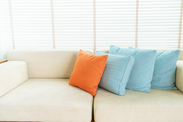 Almohada en sofá y silla de decoración en salón