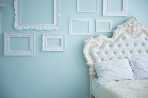 Almohadas blancas en la cama en dormitorio de estilo retro