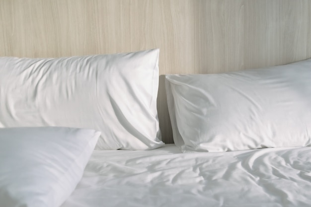 Almohadas en la cama blanca con luz de la mañana en un hotel