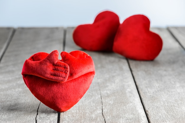 Almohadas de forma de corazón rojo sobre fondo de madera