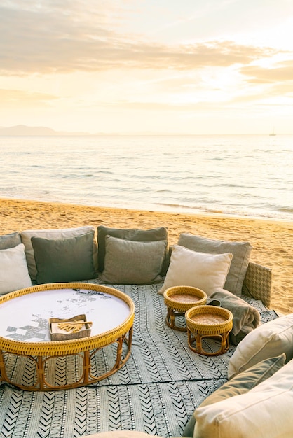 almohadas en la tumbona del patio al aire libre en la playa con fondo de puesta de sol