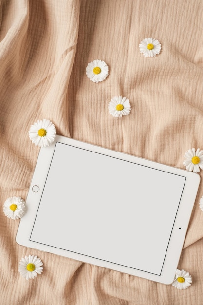 Almohadilla de tableta de pantalla de ruta de recorte en blanco con espacio de copia de maqueta y rama floral seca y tela de muselina beige neutra Vista superior plana estética