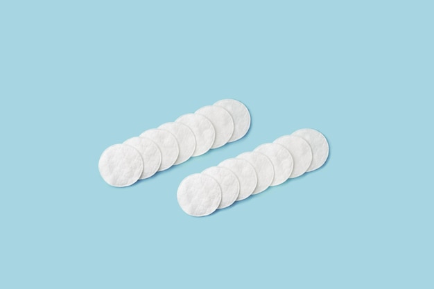 Almohadillas de algodón blanco orgánico sobre un fondo azul pastel Concepto de medicina de higiene cuidado de la salud