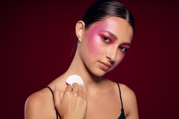 Almohadillas de algodón de mujer de moda cuero limpio maquillaje brillante posando vista recortada inalterada