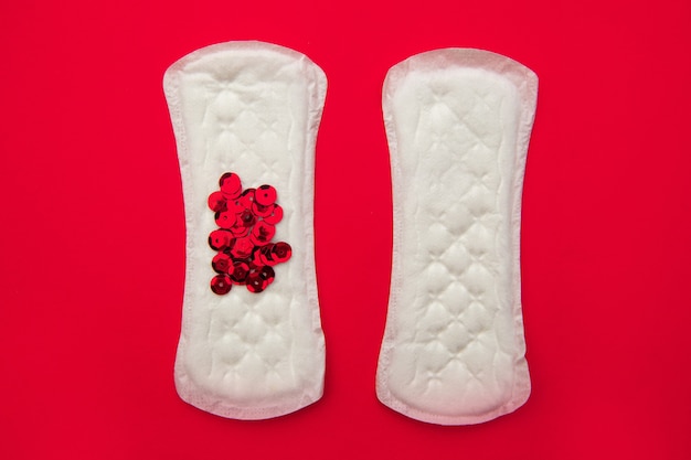 Almohadillas menstruales con brillo rojo brillante sobre rojo