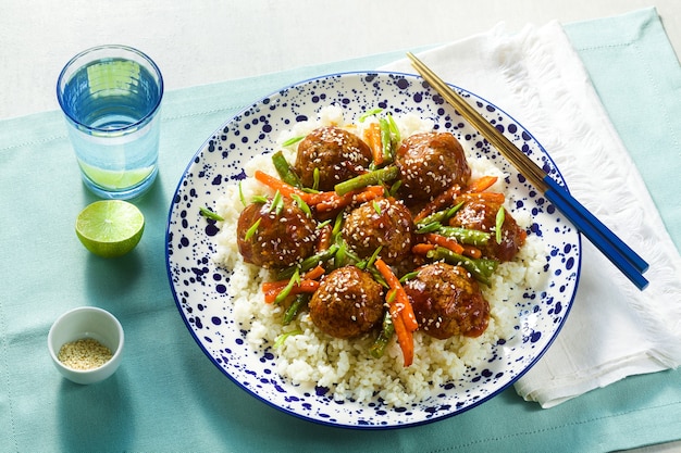 Almôndegas asiáticas veganas sem carne em molho agridoce com arroz e legumes cozidos. almoço balanceado ou jantar saudável. comida de rua