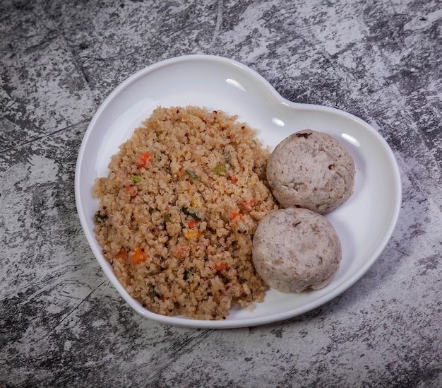 Almôndegas de filé de frango com quinoa guarnecido com legumes no plano de fundo texturizado